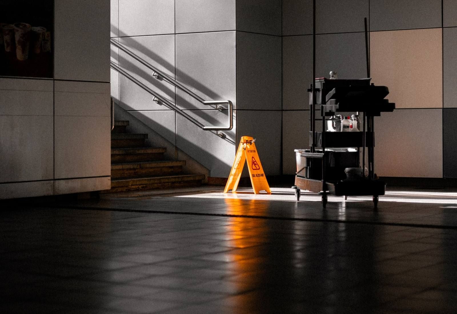 Cleaning cart and wet-floor sign in a quiet corridor